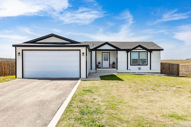 view of front of property with aphalt driveway, a front yard, an attached garage, and fence