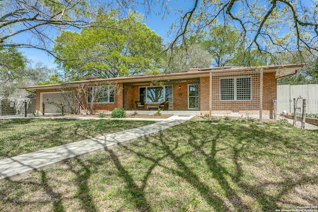ranch-style home with a front lawn, brick siding, an attached garage, and fence