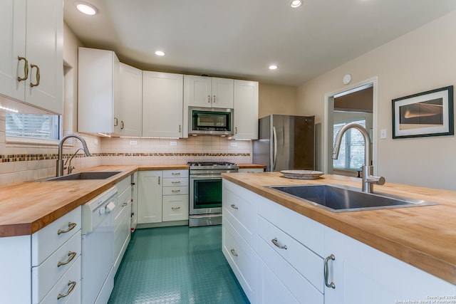 kitchen featuring a sink, wood counters, and stainless steel appliances
