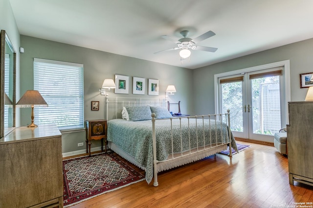 bedroom with french doors, wood finished floors, multiple windows, and access to exterior