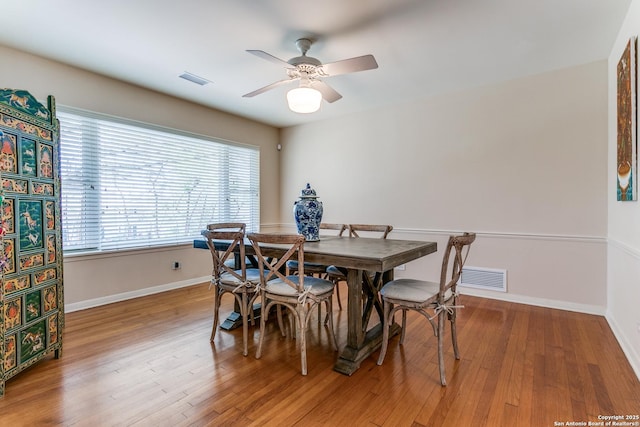 dining room with visible vents, baseboards, wood finished floors, and a ceiling fan