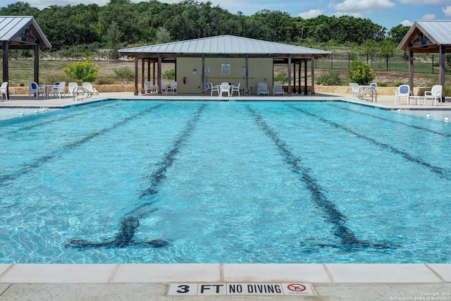 community pool with a gazebo, a patio area, and fence