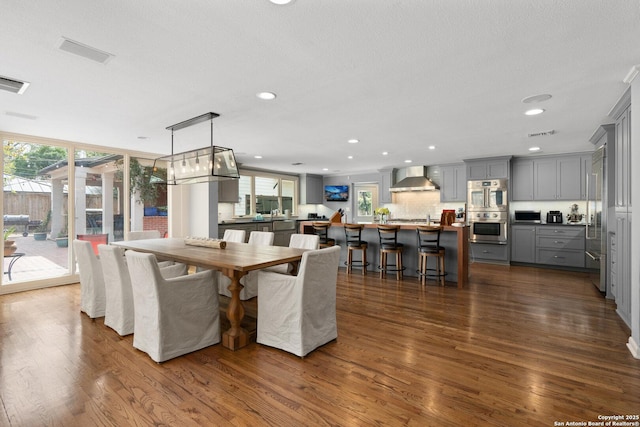 dining area featuring a wealth of natural light, dark wood-style floors, and recessed lighting