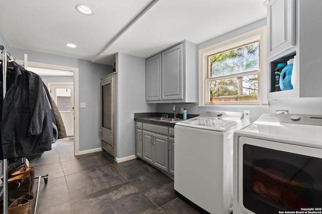 laundry room featuring baseboards, recessed lighting, cabinet space, a sink, and washer and clothes dryer