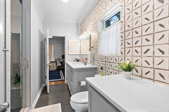 bathroom featuring baseboards, toilet, a stall shower, wood finished floors, and vanity