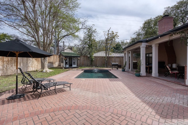 view of swimming pool with an outbuilding, a patio, a fenced in pool, an in ground hot tub, and a fenced backyard