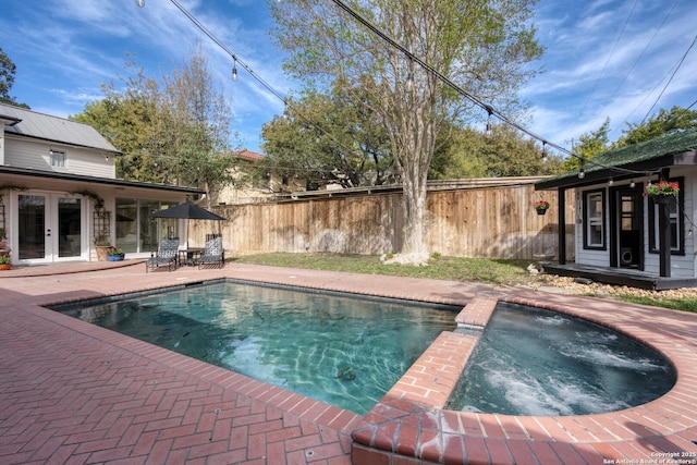 view of pool with a patio, french doors, fence, and an in ground hot tub