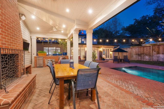 patio at twilight featuring outdoor dining area, a fenced in pool, a ceiling fan, and fence