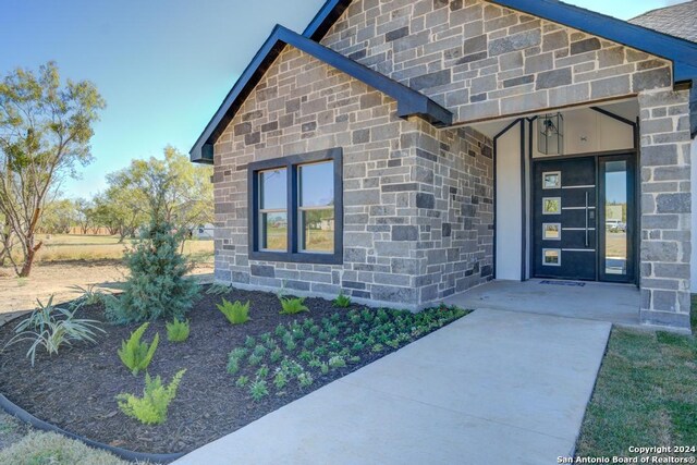 116 Hidden Ranch Ct, Floresville, TX 78114 - doorway to property with stone siding
