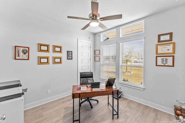 home office with a ceiling fan, baseboards, and light wood-type flooring