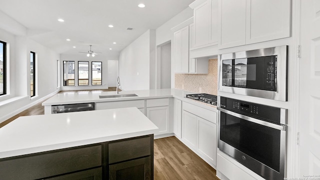 4971 Park Mnr, Schertz, TX 78124 - kitchen featuring stainless steel appliances, a sink, a peninsula, light countertops, and light wood finished floors