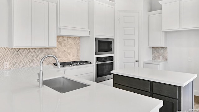 4971 Park Mnr, Schertz, TX 78124 - kitchen with stainless steel appliances, a sink, tasteful backsplash, light countertops, and white cabinetry