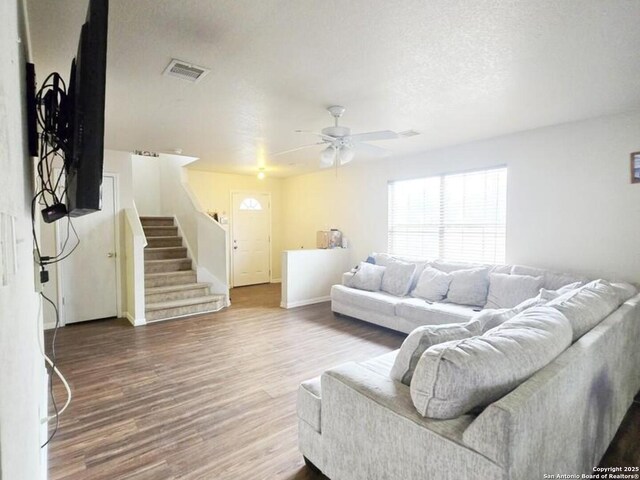 9991 Hawksbill Peak, San Antonio, TX 78245 - living room featuring stairway, a ceiling fan, wood finished floors, visible vents, and a textured ceiling