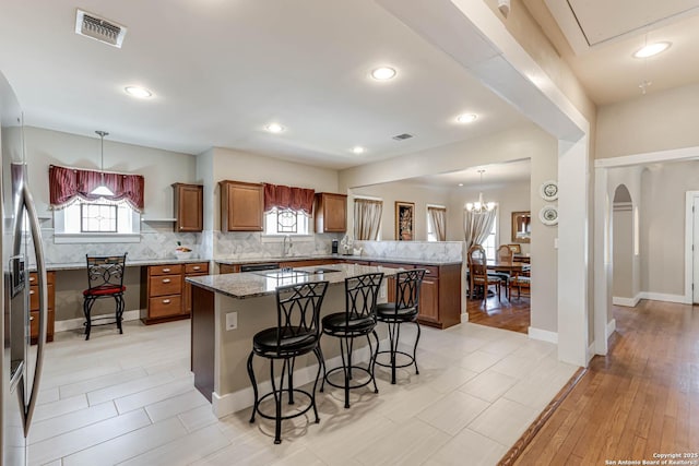 2106 W Gramercy Pl, San Antonio, TX 78201 - kitchen featuring a kitchen bar, stainless steel fridge, a peninsula, and visible vents