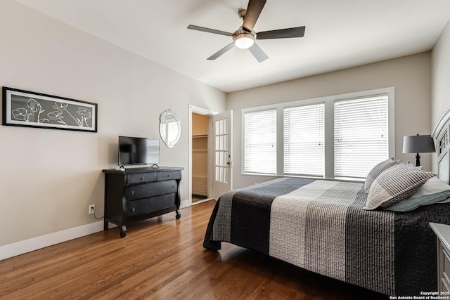 2106 W Gramercy Pl, San Antonio, TX 78201 - bedroom with a walk in closet, wood finished floors, baseboards, and ceiling fan