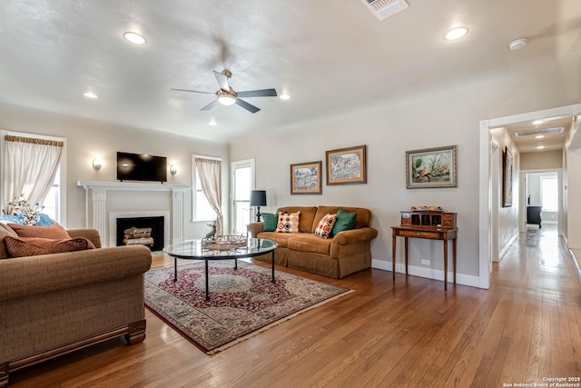2106 W Gramercy Pl, San Antonio, TX 78201 - living area featuring visible vents, baseboards, a fireplace with flush hearth, wood finished floors, and a ceiling fan
