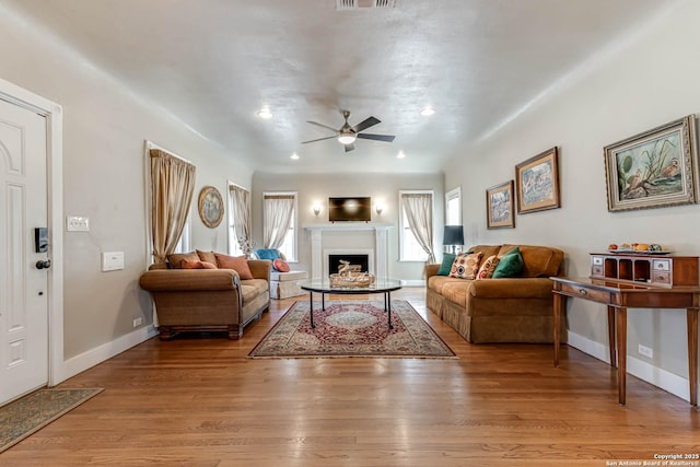 2106 W Gramercy Pl, San Antonio, TX 78201 - living room featuring a healthy amount of sunlight, a fireplace, light wood-style floors, and a ceiling fan