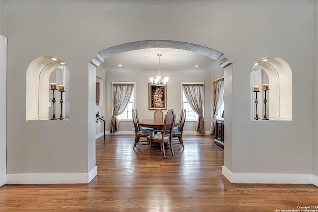 2106 W Gramercy Pl, San Antonio, TX 78201 - dining space featuring arched walkways, a chandelier, baseboards, and wood finished floors