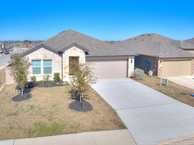 single story home with concrete driveway, roof with shingles, a front yard, stone siding, and an attached garage