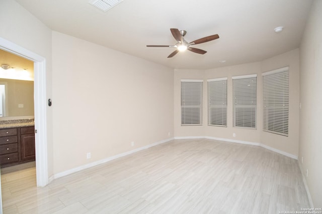 empty room with light wood-type flooring, visible vents, baseboards, and a ceiling fan