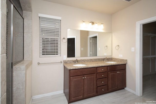 bathroom with double vanity, visible vents, baseboards, and a sink