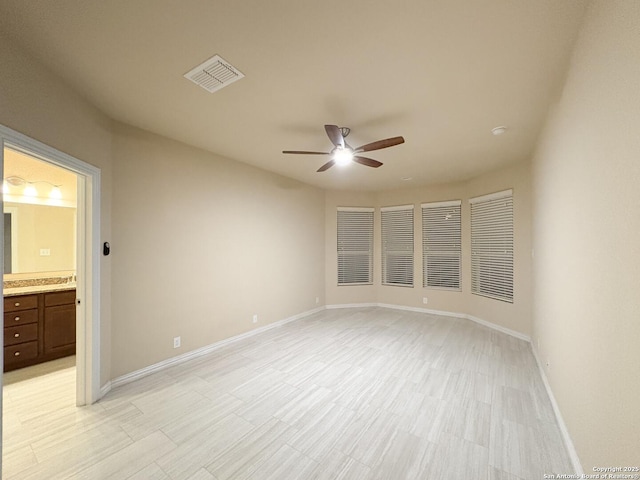 unfurnished room featuring visible vents, baseboards, and ceiling fan