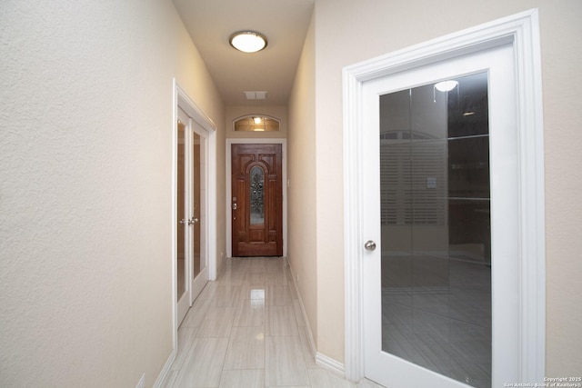 corridor featuring visible vents and baseboards