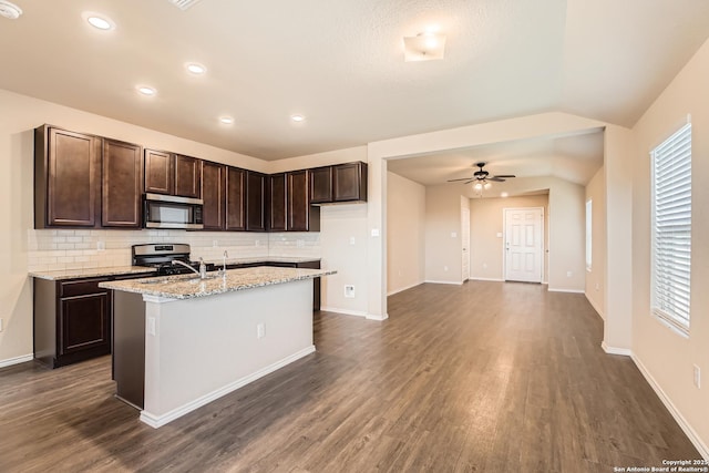 2066 Chelsea, New Braunfels, TX 78130 - kitchen with dark brown cabinetry, a center island with sink, dark wood-style flooring, and stainless steel appliances