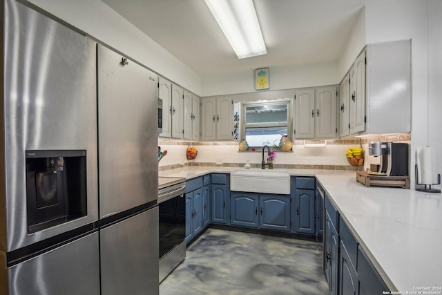 kitchen with tasteful backsplash, appliances with stainless steel finishes, light countertops, and a sink