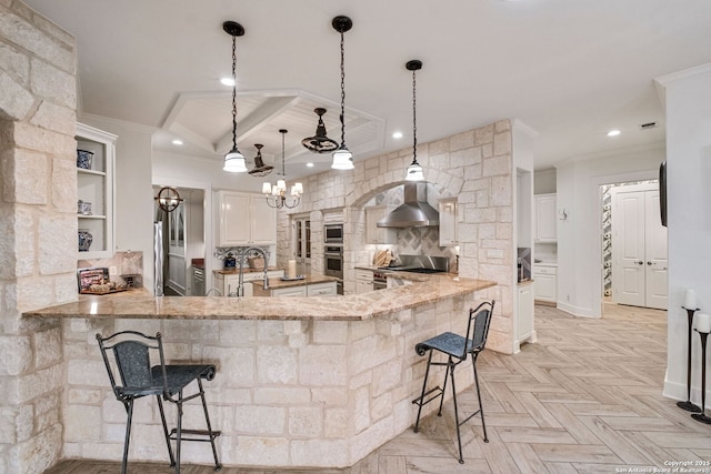1626 Cordillera Trce, Boerne, TX 78006 - kitchen with light stone counters, decorative backsplash, a breakfast bar, stainless steel appliances, and wall chimney exhaust hood