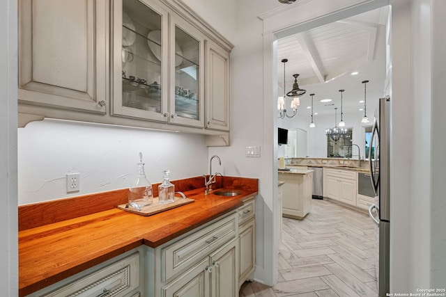 1626 Cordillera Trce, Boerne, TX 78006 - kitchen featuring stainless steel dishwasher, pendant lighting, a sink, and glass insert cabinets