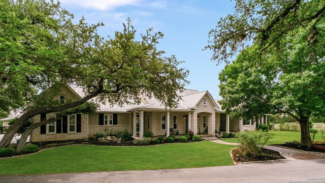 1626 Cordillera Trce, Boerne, TX 78006 - view of front of house with stone siding, metal roof, a porch, a front yard, and a standing seam roof