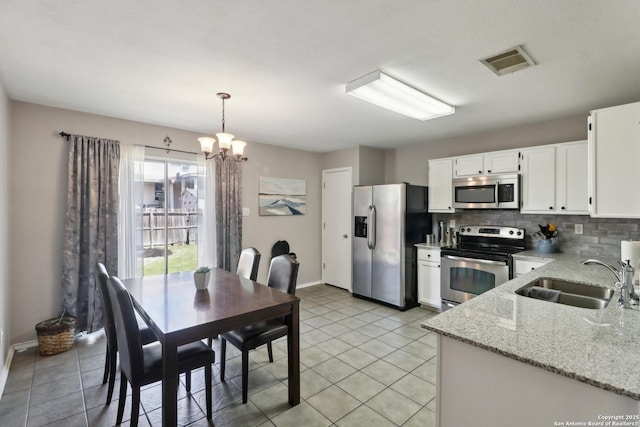434 Golden Walk, San Antonio, TX 78227 - kitchen with visible vents, a notable chandelier, a sink, tasteful backsplash, and stainless steel appliances
