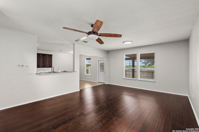 unfurnished living room featuring baseboards, visible vents, wood finished floors, and ceiling fan