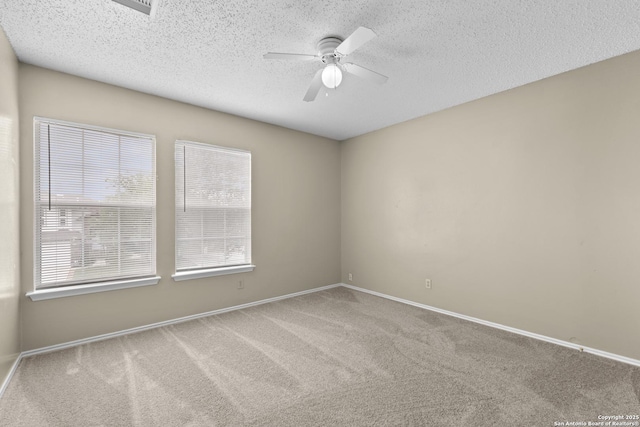 empty room featuring carpet flooring, a textured ceiling, ceiling fan, and baseboards