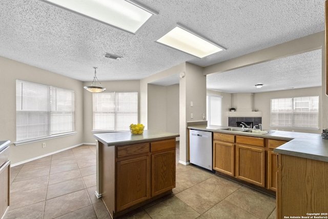 kitchen with a sink, a textured ceiling, light tile patterned floors, and dishwasher