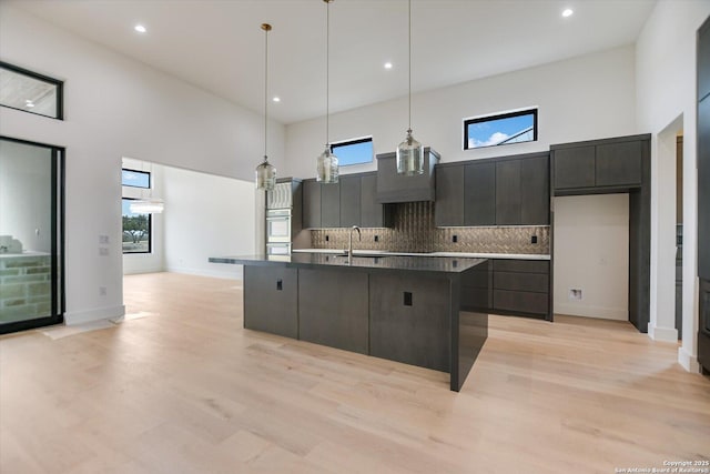 130 Azalea Loop, Horseshoe Bay, TX 78657 - kitchen featuring a sink, tasteful backsplash, modern cabinets, and a towering ceiling