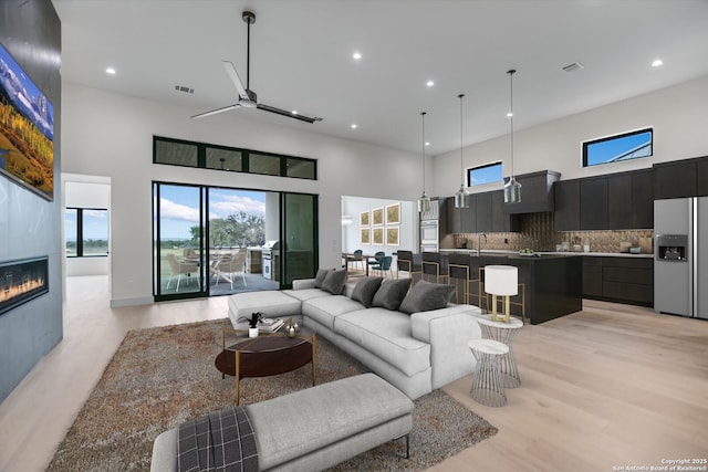 130 Azalea Loop, Horseshoe Bay, TX 78657 - living room featuring ceiling fan, visible vents, a towering ceiling, and light wood finished floors