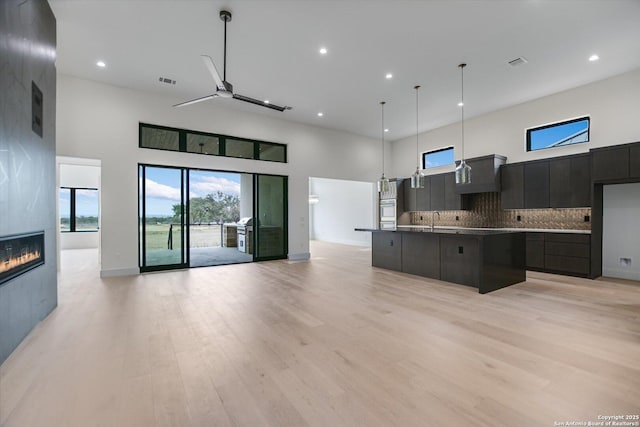 130 Azalea Loop, Horseshoe Bay, TX 78657 - kitchen with backsplash, modern cabinets, open floor plan, and a towering ceiling
