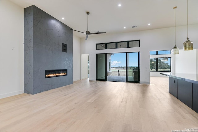 130 Azalea Loop, Horseshoe Bay, TX 78657 - unfurnished living room with recessed lighting, light wood-type flooring, a high ceiling, and visible vents