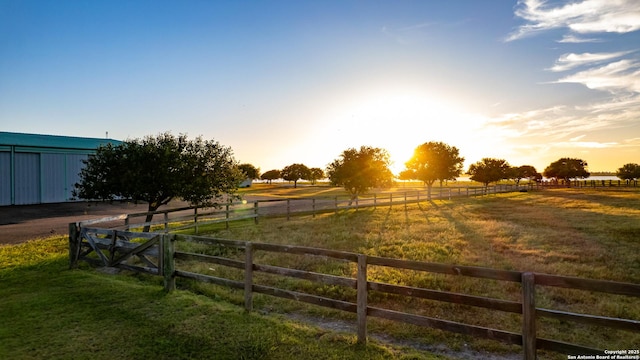 yard at dusk with a rural view and fence