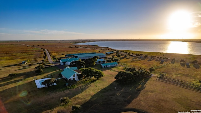 aerial view at dusk with a rural view and a water view