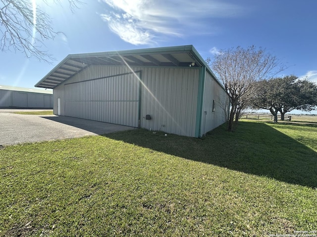 view of property exterior with a yard, an outbuilding, an outdoor structure, and fence