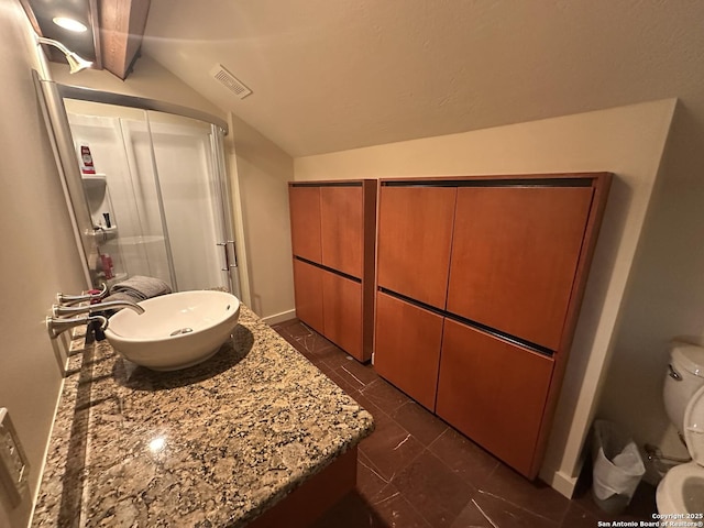 bathroom with visible vents, a shower stall, baseboards, vaulted ceiling, and vanity