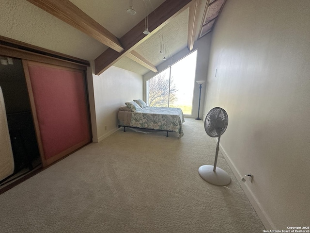 bedroom featuring baseboards, vaulted ceiling with beams, and carpet flooring