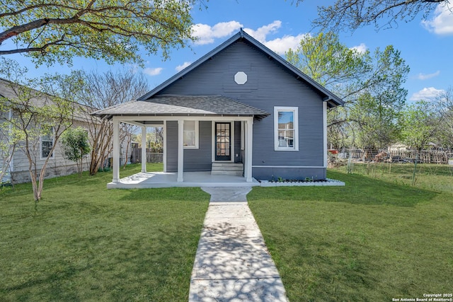 view of front of house featuring a front lawn, fence, and roof with shingles