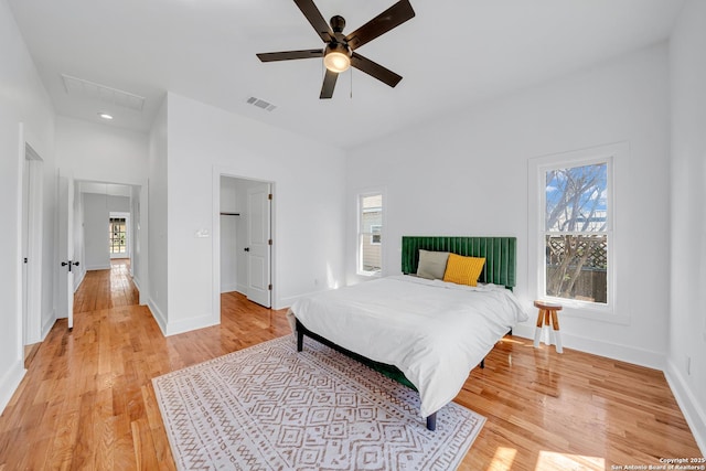 bedroom featuring light wood-type flooring, visible vents, and multiple windows