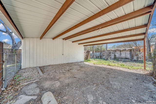 view of patio / terrace featuring a carport, a gate, fence, and an outdoor structure