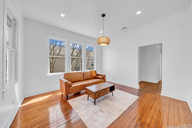 living room featuring visible vents, wood-type flooring, and baseboards