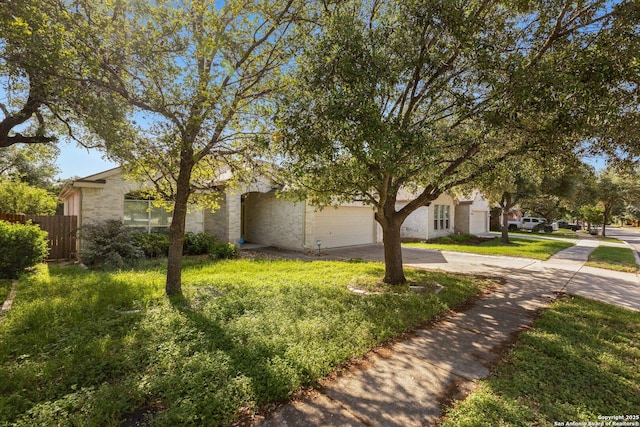 14204 Auberry, Helotes, TX 78023 - view of property hidden behind natural elements featuring driveway, fence, a garage, and brick siding